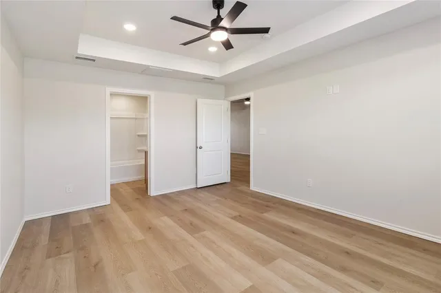 an empty room with closet and a ceiling fan
