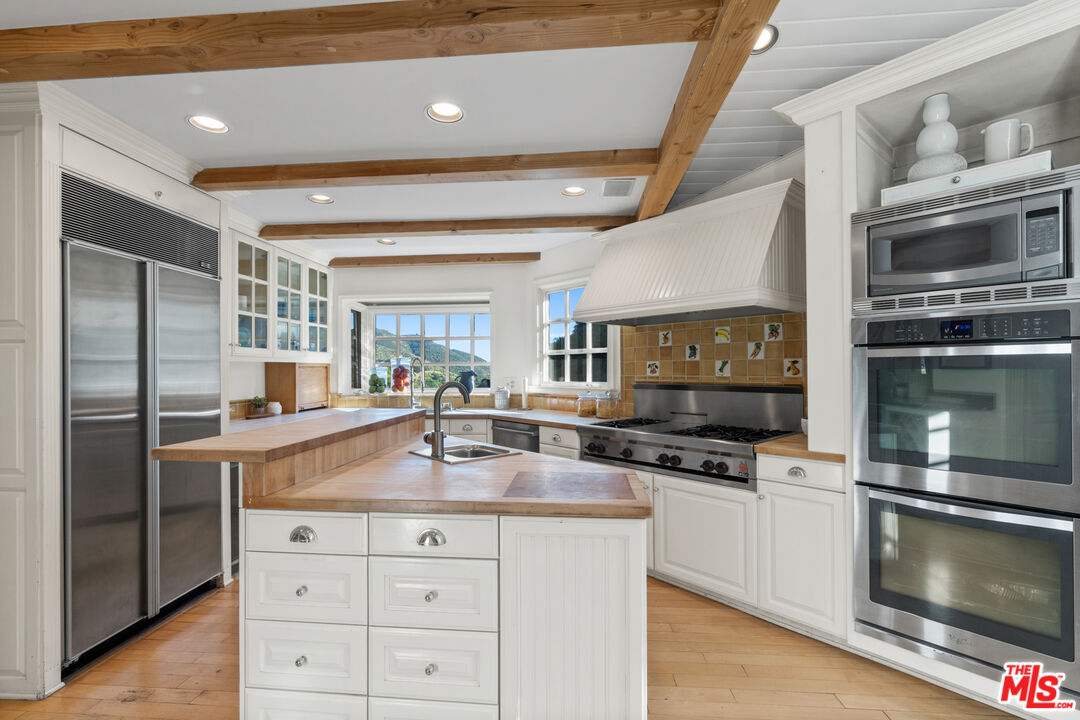3371 Mandeville Canyon Road Los Angeles, CA 90049 - Photo 14 of 44 a kitchen with a stove and a microwave