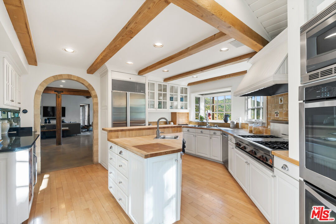 3371 Mandeville Canyon Road Los Angeles, CA 90049 - Photo 15 of 44 a large kitchen with stainless steel appliances granite countertop a large counter top and stove