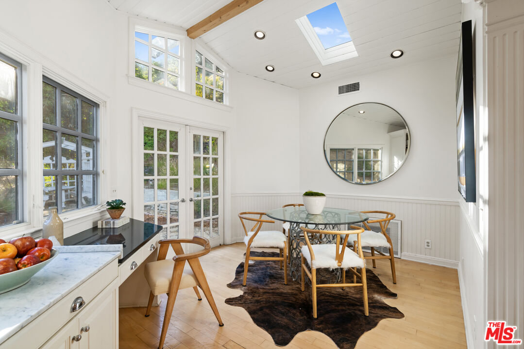 3371 Mandeville Canyon Road Los Angeles, CA 90049 - Photo 17 of 44 a view of a dining room with furniture and a large window