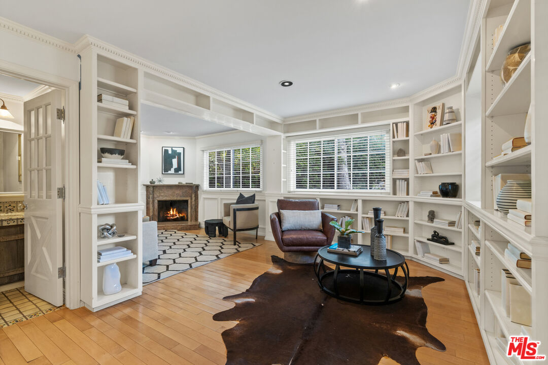 3371 Mandeville Canyon Road Los Angeles, CA 90049 - Photo 18 of 44 a living room with fireplace furniture and a floor to ceiling window