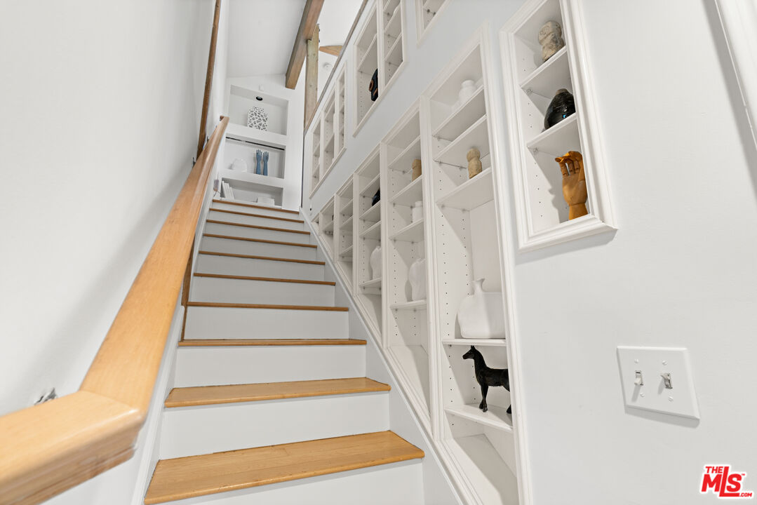 3371 Mandeville Canyon Road Los Angeles, CA 90049 - Photo 31 of 44 a view of staircase with lots of frames on wall