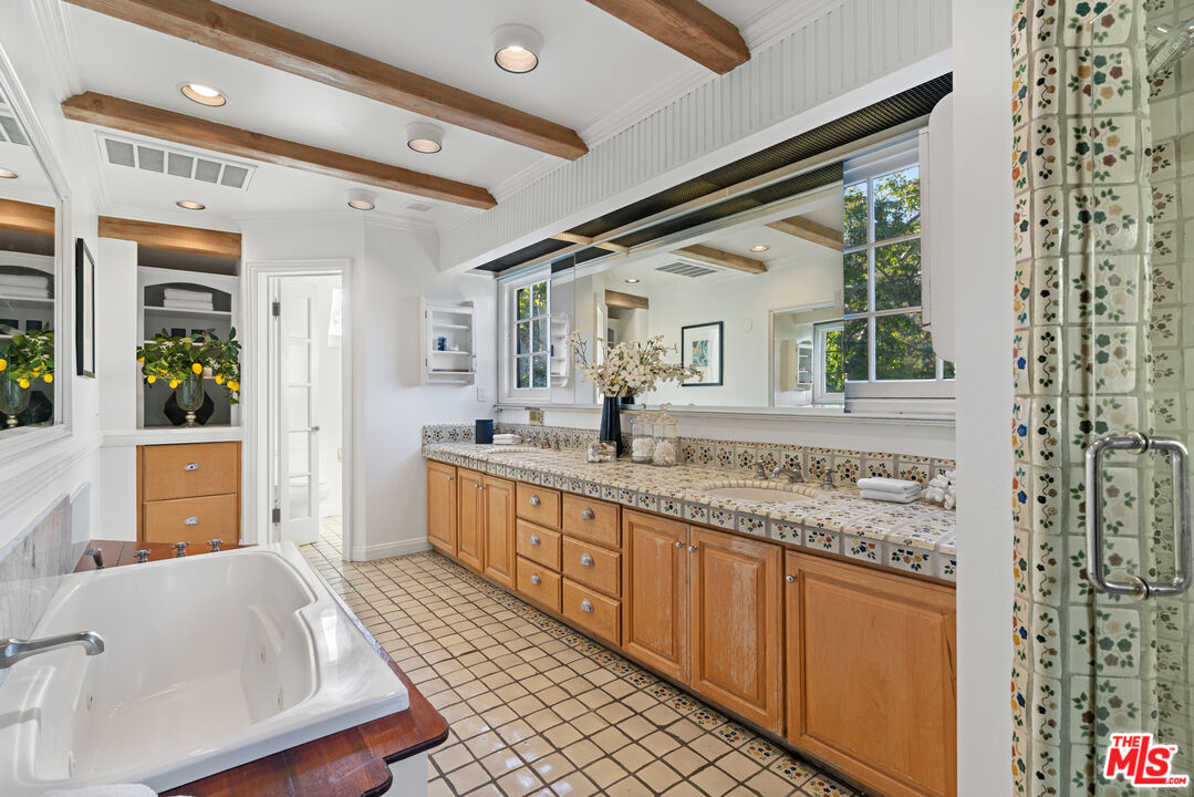 3371 Mandeville Canyon Road Los Angeles, CA 90049 - Photo 35 of 44 a bathroom with a granite countertop sink mirror and shower