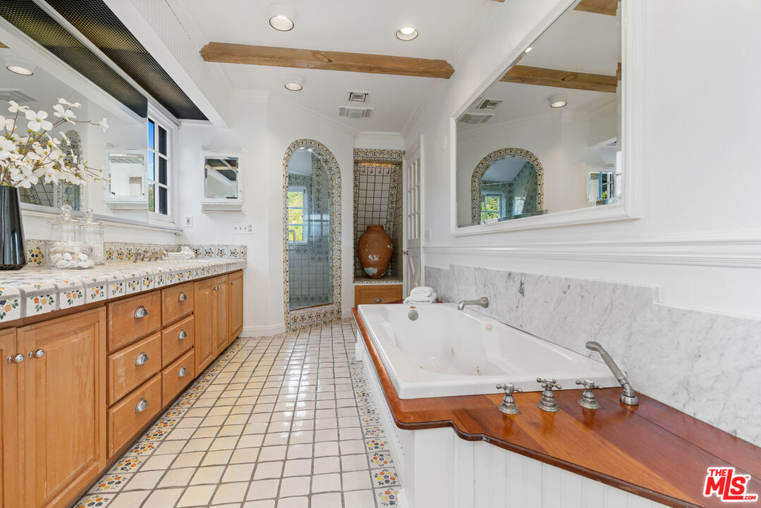 3371 Mandeville Canyon Road Los Angeles, CA 90049 - Photo 36 of 44 a bathroom with a tub sink and mirror