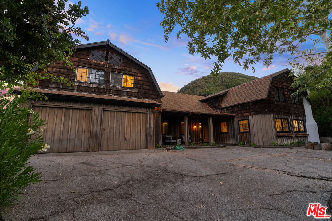 3371 Mandeville Canyon Road Los Angeles, CA 90049 - Photo 4 of 44 a view of a house with a garage