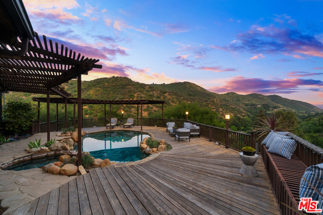 3371 Mandeville Canyon Road Los Angeles, CA 90049 - Photo 41 of 44 a view of a rooftop deck with couch and chairs