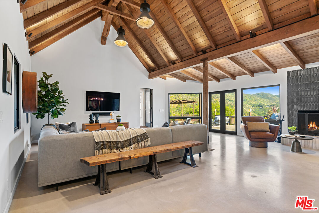3371 Mandeville Canyon Road Los Angeles, CA 90049 - Photo 6 of 44 a living room with furniture and a flat screen tv