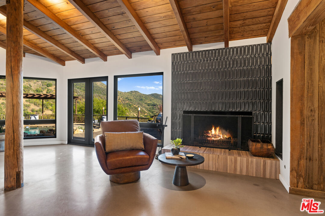 3371 Mandeville Canyon Road Los Angeles, CA 90049 - Photo 7 of 44 a living room with furniture and a fireplace