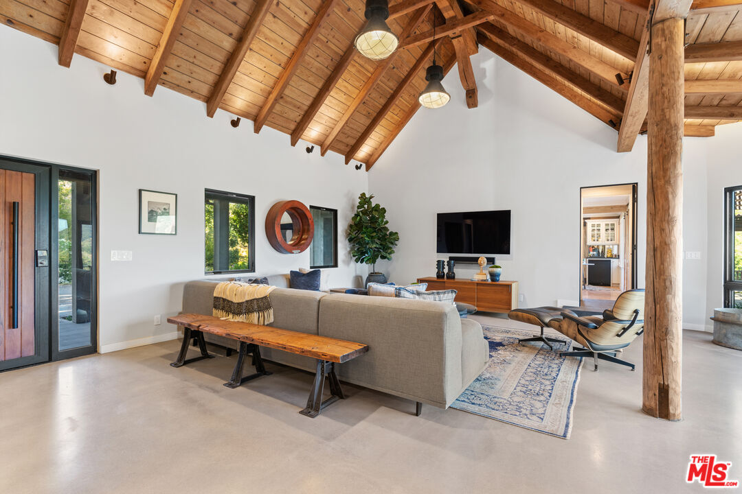 3371 Mandeville Canyon Road Los Angeles, CA 90049 - Photo 8 of 44 a living room with furniture and a flat screen tv