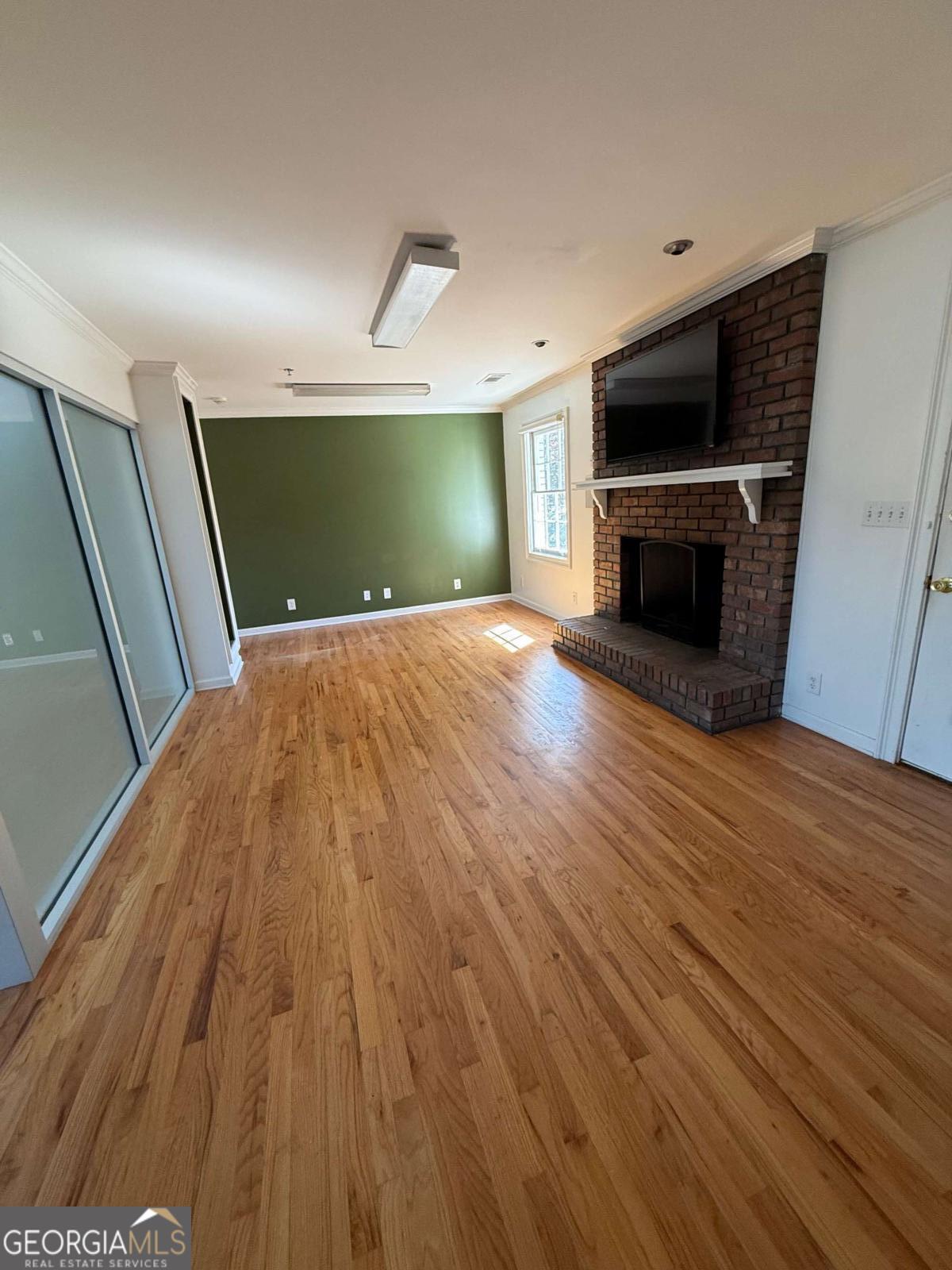 1001 Oak Road Southwest, Unit 1 Lilburn, GA 30047 - Photo 4 of 12 a view of empty room with wooden floor and fireplace