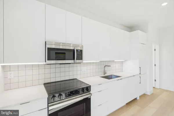 a kitchen with granite countertop a stove and a sink
