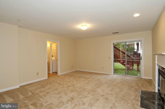 2247 Conquest Way, Unit 63 Odenton, MD 21113 - Photo 16 of 30 an empty room with sliding door and wooden floor