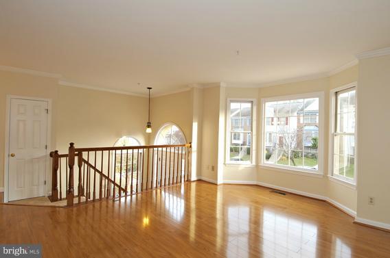 2247 Conquest Way, Unit 63 Odenton, MD 21113 - Photo 5 of 30 a view of an empty room with wooden floor and a window