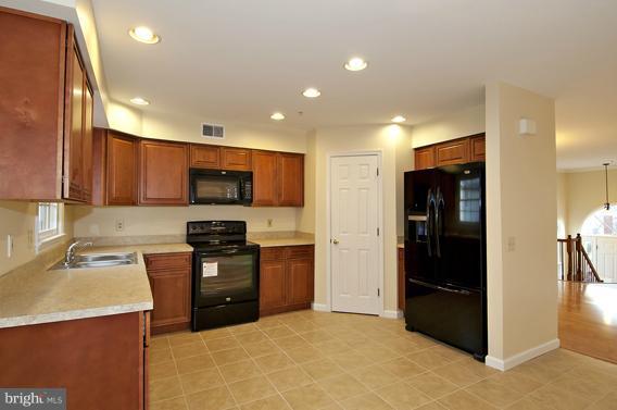 2247 Conquest Way, Unit 63 Odenton, MD 21113 - Photo 10 of 30 a kitchen with stainless steel appliances granite countertop a refrigerator and a stove top oven