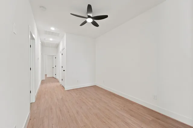 a view of room with a ceiling fan and wooden floor