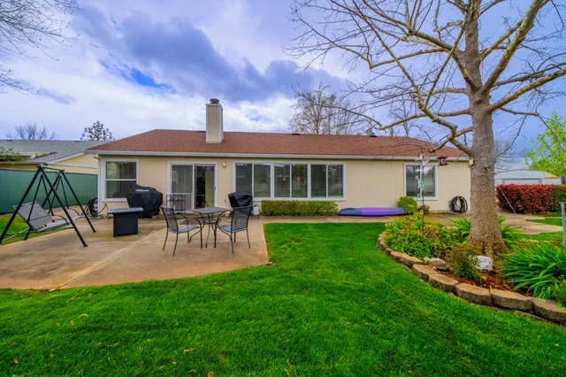a view of a house with a yard and sitting area