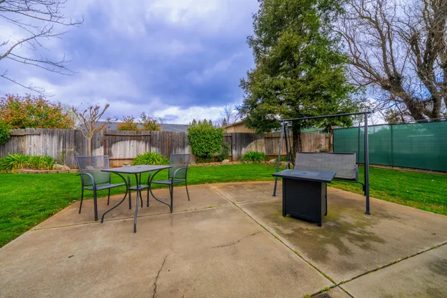 a view of house with backyard and outdoor seating