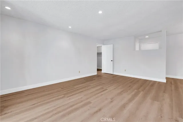 a view of hallway with window and wooden floor