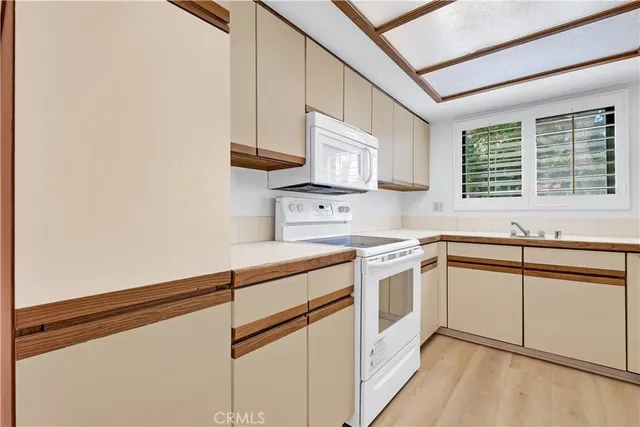 a kitchen with white cabinets and white appliances