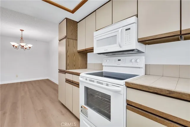 a kitchen with granite countertop white cabinets and white appliances