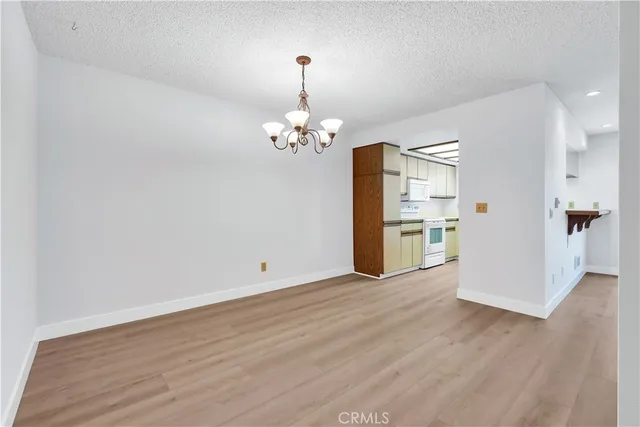 a view of a kitchen with wooden floor and a refrigerator