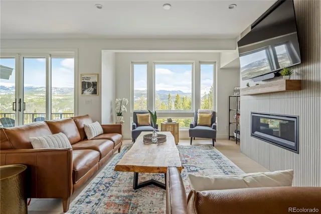 a living room with furniture large window and a fireplace