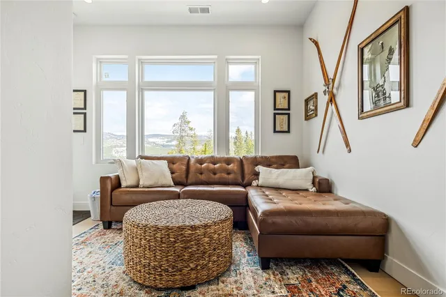 a living room with furniture a large window and a rug