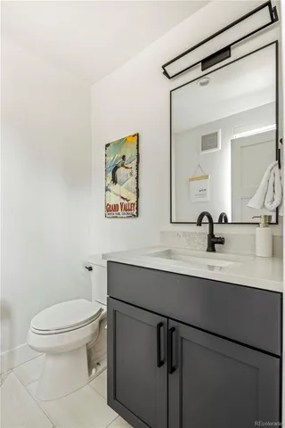 a bathroom with a toilet a sink and mirror