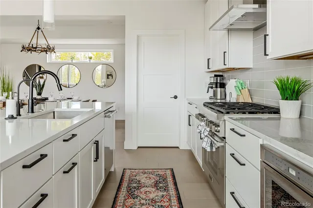 a kitchen with granite countertop a sink stove and cabinets
