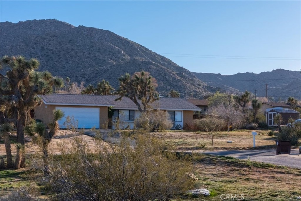 60432 Latham Trail Joshua Tree, CA 92252 - Photo 23 of 25 a view of a white house next to a road with a building in the background