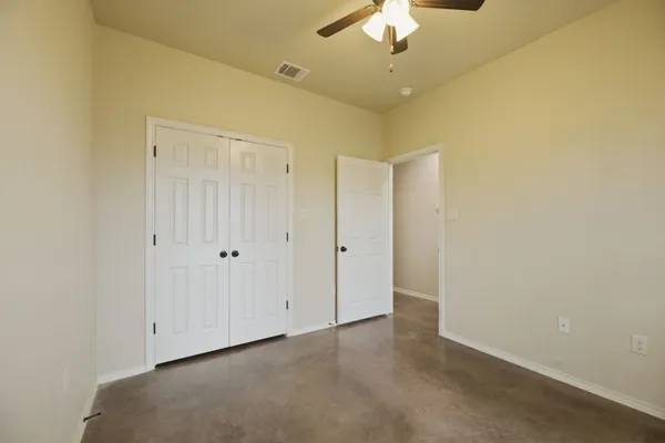 an empty room with a ceiling fan and a chandelier fan
