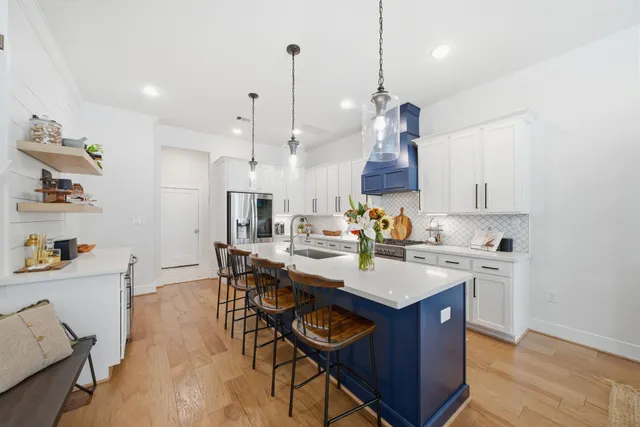 a kitchen with a sink a stove and chairs