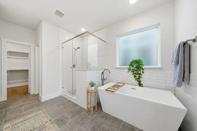 a white bath tub sitting in a bathroom and mirror