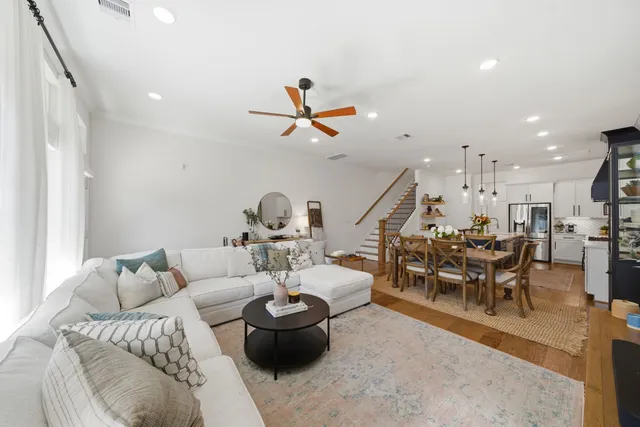 a open kitchen with stainless steel appliances granite countertop a stove top oven a sink a dining table and chairs with the wooden floor