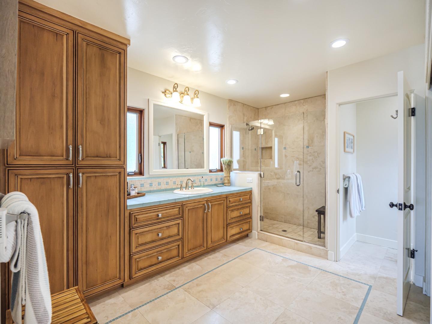 431 Beach Drive Aptos, CA 95003 - Photo 22 of 47 a bathroom with a glass door shower a sink and a mirror