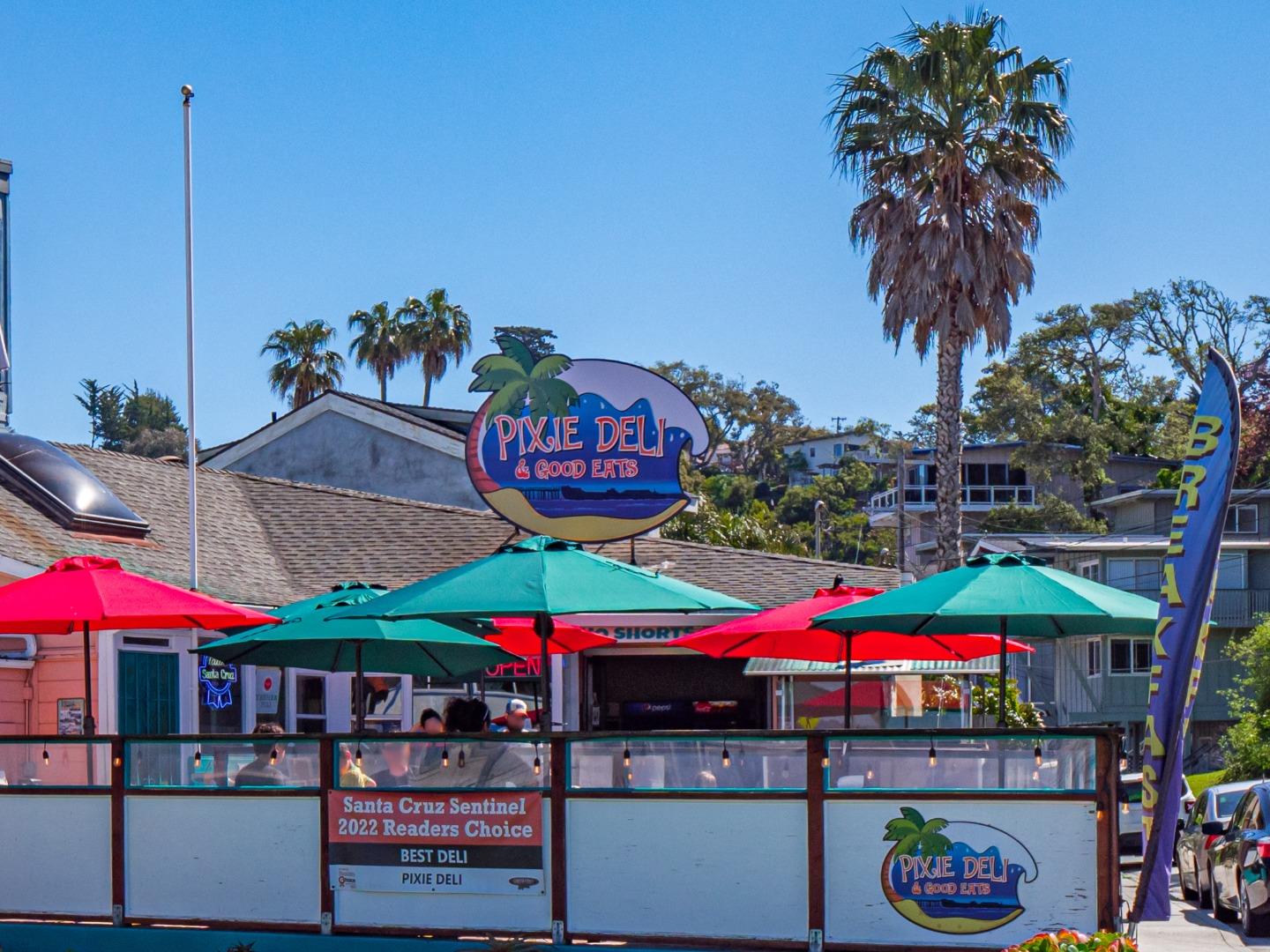 431 Beach Drive Aptos, CA 95003 - Photo 44 of 47 a group of tables and chairs with umbrellas in front of retail shops