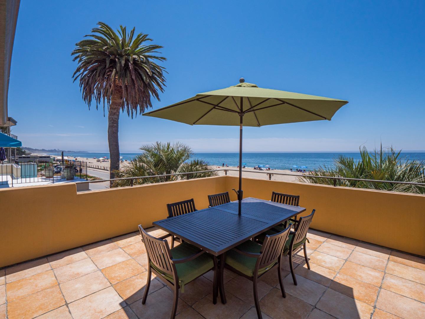 431 Beach Drive Aptos, CA 95003 - Photo 8 of 47 a blue swimming pool with a table and chairs under an umbrella