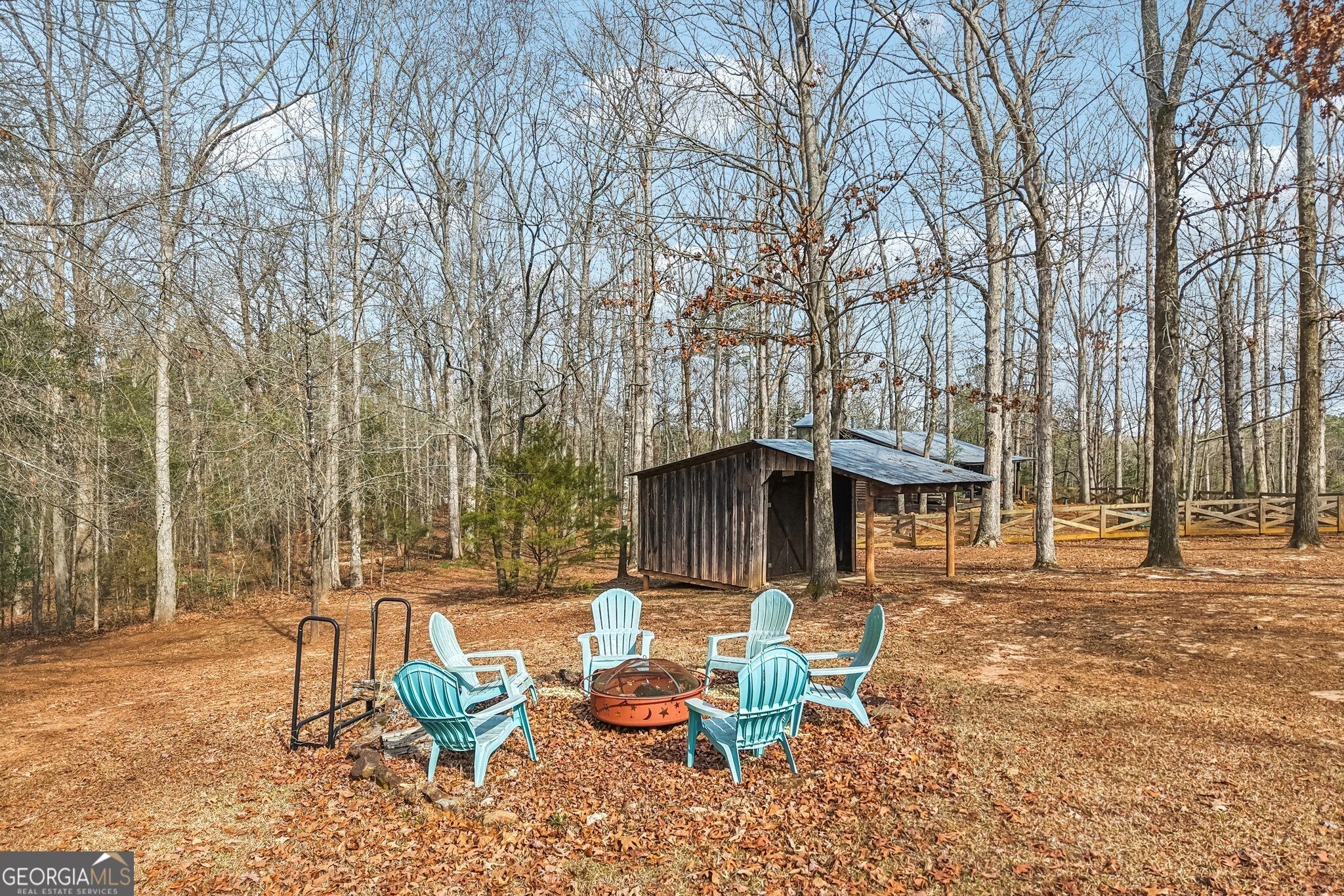 1015 Adams Road West Point, GA 31833 - Photo 103 of 108 a view of a patio with table and chairs with wooden fence and large trees