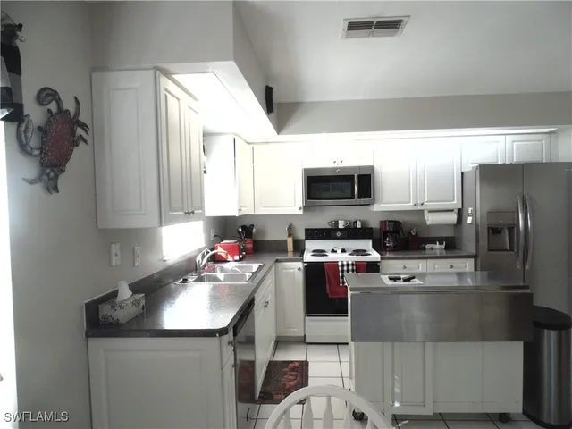 a kitchen with a sink stainless steel appliances and white cabinets