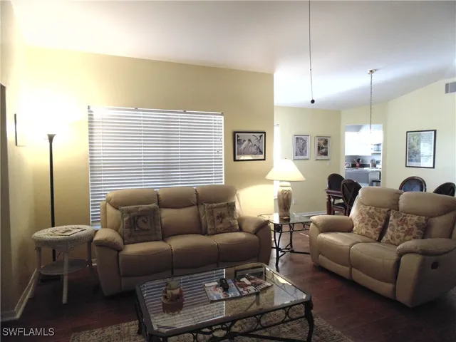 a living room with furniture a lamp and a window