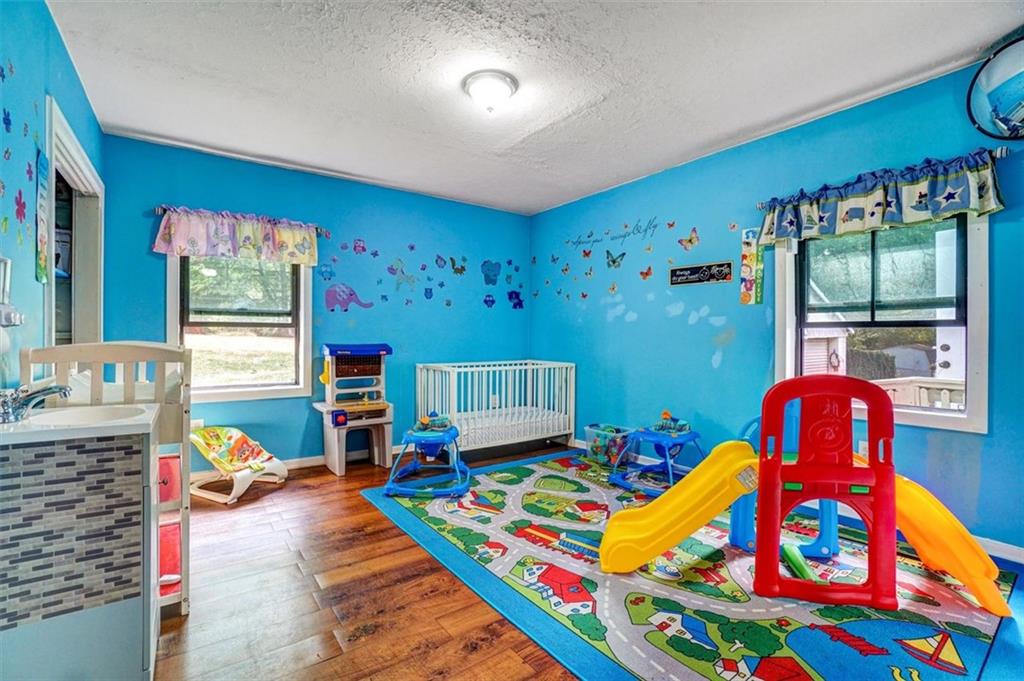 5099 Austell Powder Springs Road Southwest Austell, GA 30106 - Photo 17 of 38 a bedroom with a bed and wooden floor