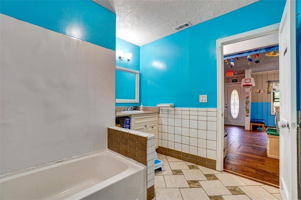 5099 Austell Powder Springs Road Southwest Austell, GA 30106 - Photo 23 of 38 a bathroom with a bathtub and shower