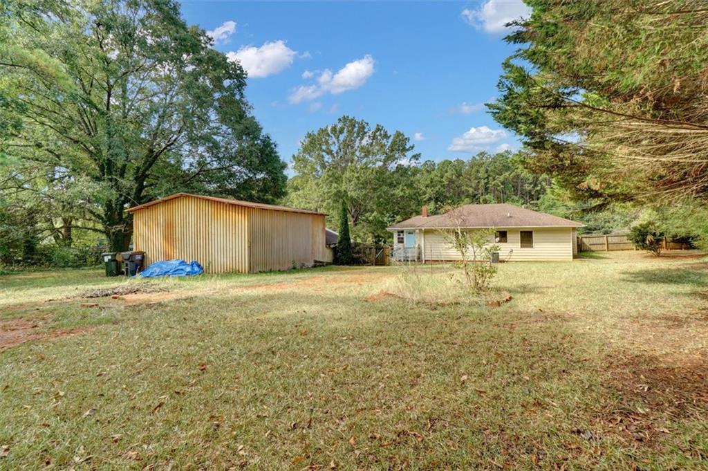 5099 Austell Powder Springs Road Southwest Austell, GA 30106 - Photo 28 of 38 a front view of a house with yard and trees