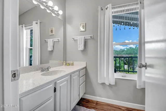 a bathroom with a sink a mirror a vanity and a shower