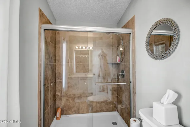 a bathroom with a glass shower door and a sink