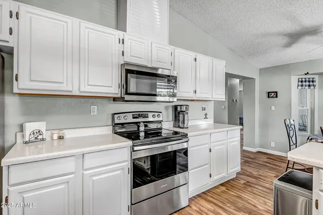 a kitchen with cabinets appliances a sink and a counter top space