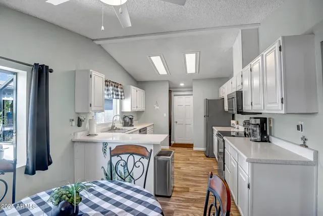 a kitchen that has a lot of cabinets in it and wooden floor