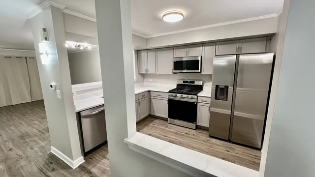 a kitchen with stainless steel appliances kitchen island granite countertop a refrigerator stove and sink