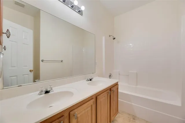 a bathroom with a tub sink and mirror
