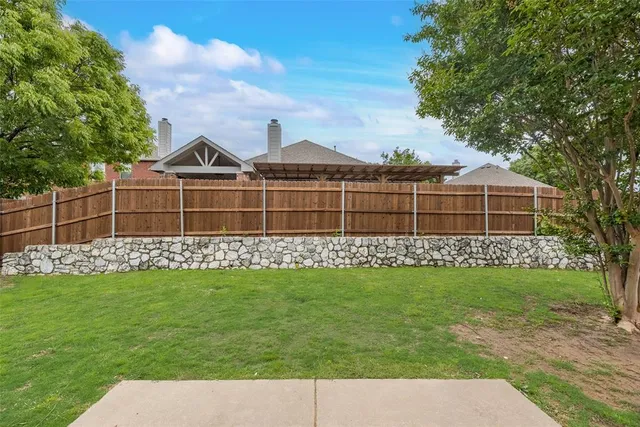 a view of a garden with a house in the background